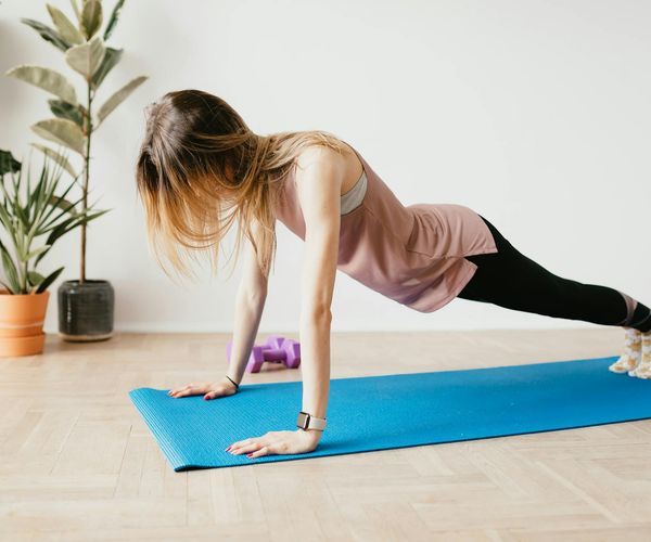 A serene scene with yoga mats and plants in a well-lit room.