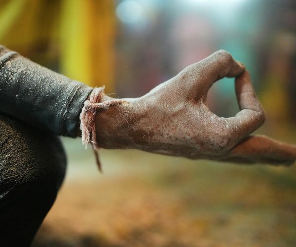 Close-up of a person's hands in a meditative mudra gesture.